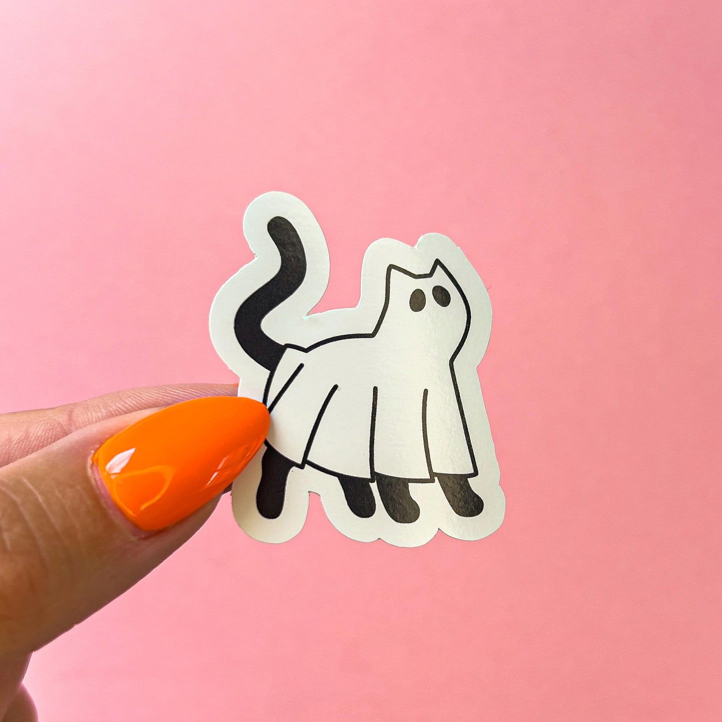 A vinyl decal sticker of a black cat wearing a ghost costume. The cat is facing forward with its tail curled. The ghost costume is white and has a simple design.