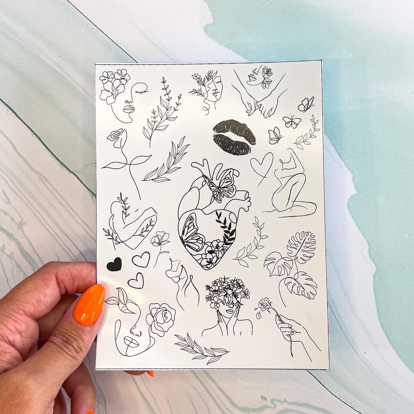 A sheet of various minimalist, black outline style stickers. The stickers include various line drawn women silhouettes, many with flowers incorporated, plants, hearts, butterflies, flowers, lips, and an anatomical heart with flowers growing within.
