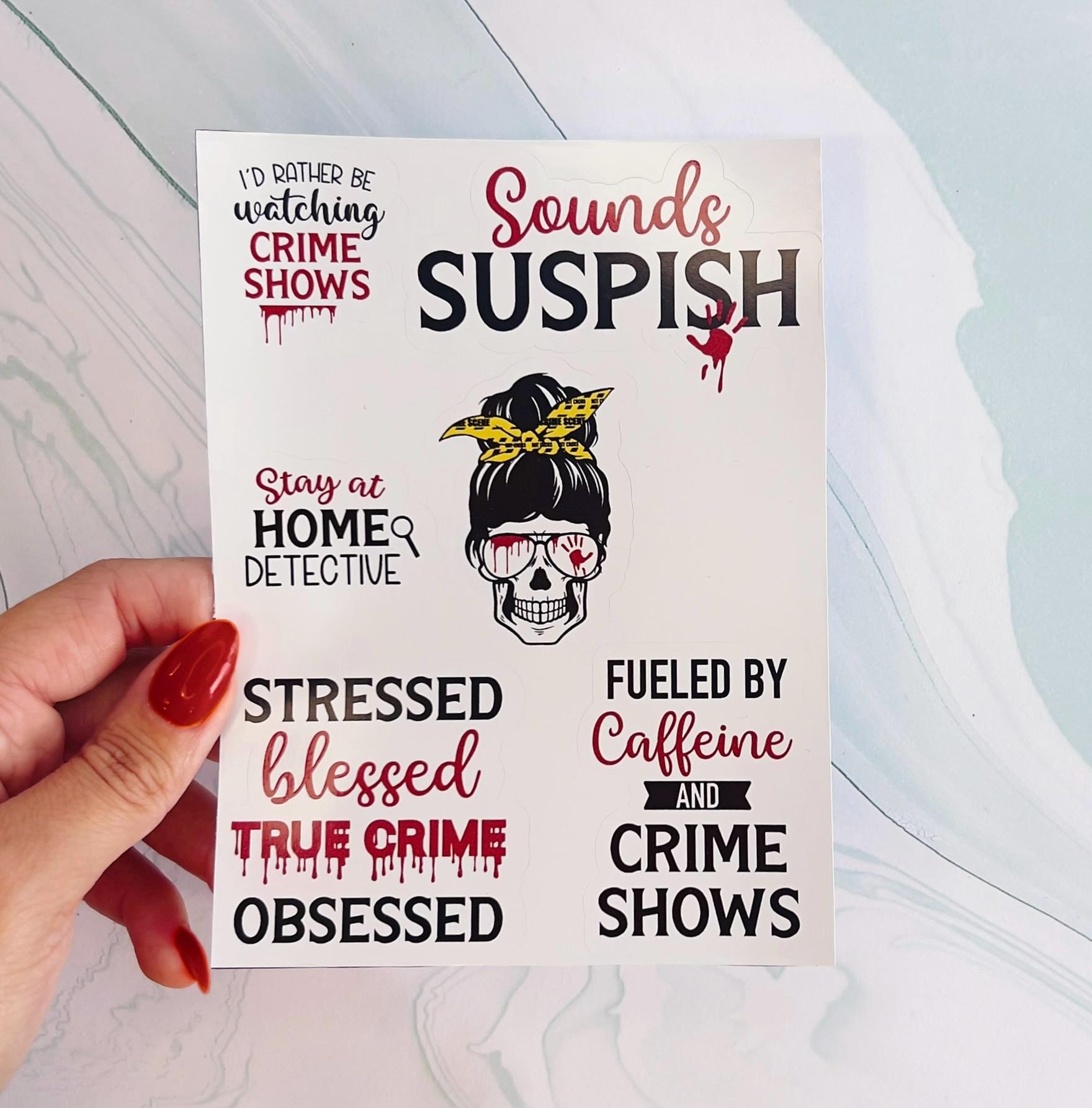 A sheet of various true crime themed stickers. The first sticker reads 'I'd rather be watching crime shows'. The second sticker reads 'Sounds suspish'. The third sticker reads 'Stay at home detective'. The fourth sticker reads 'Stressed blessed true crime obsessed'. The fifth sticker reads 'Fueled by caffeine and crime shows'. All stickers have a red blood splatter design.