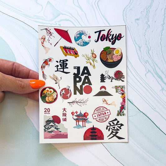 A sheet of Japanese themes stickers. The stickers include koi fish, ramen, an umbrella, "TOKYO" in black and read styled font, Japanese characters, sushi, a stamp, "JAPAN" in black and red styled font, cherry blossoms, temples, ect.
