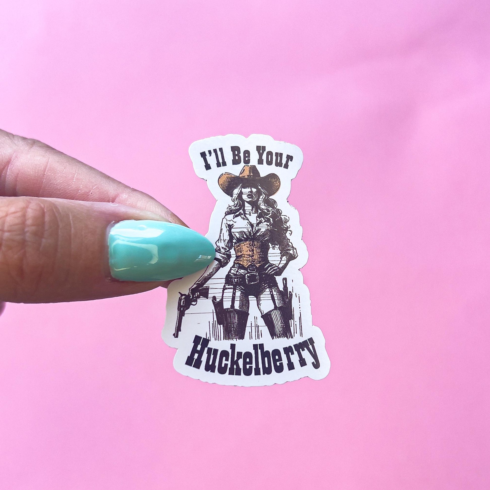 A vintage cowgirl holding a gun in her right hand with the other hand on her hip. She is wearing a cowboy hat and a holster. The text reads "I'll be your Huckleberry" in western font.