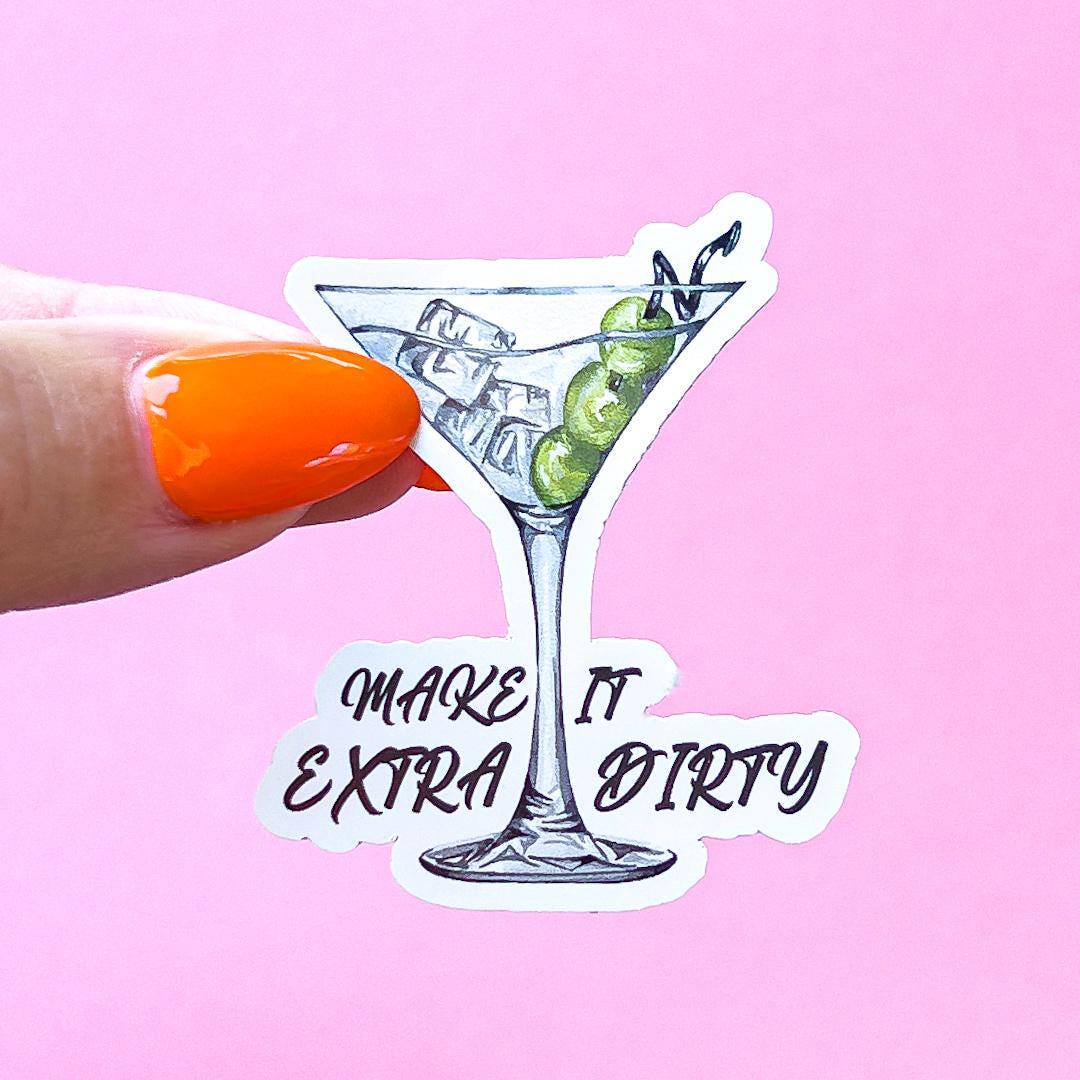 A vinyl decal sticker of a martini glass with green olives and ice. The text reads 'Make it extra dirty' in cursive font.
