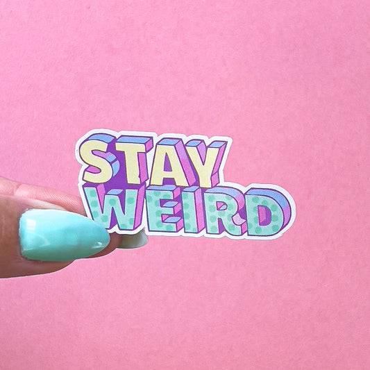 A vinyl decal sticker with the words 'STAY WEIRD' in a colorful, 3D-style font. The letters are outlined in purple and filled with a gradient of yellow, green, and blue.
