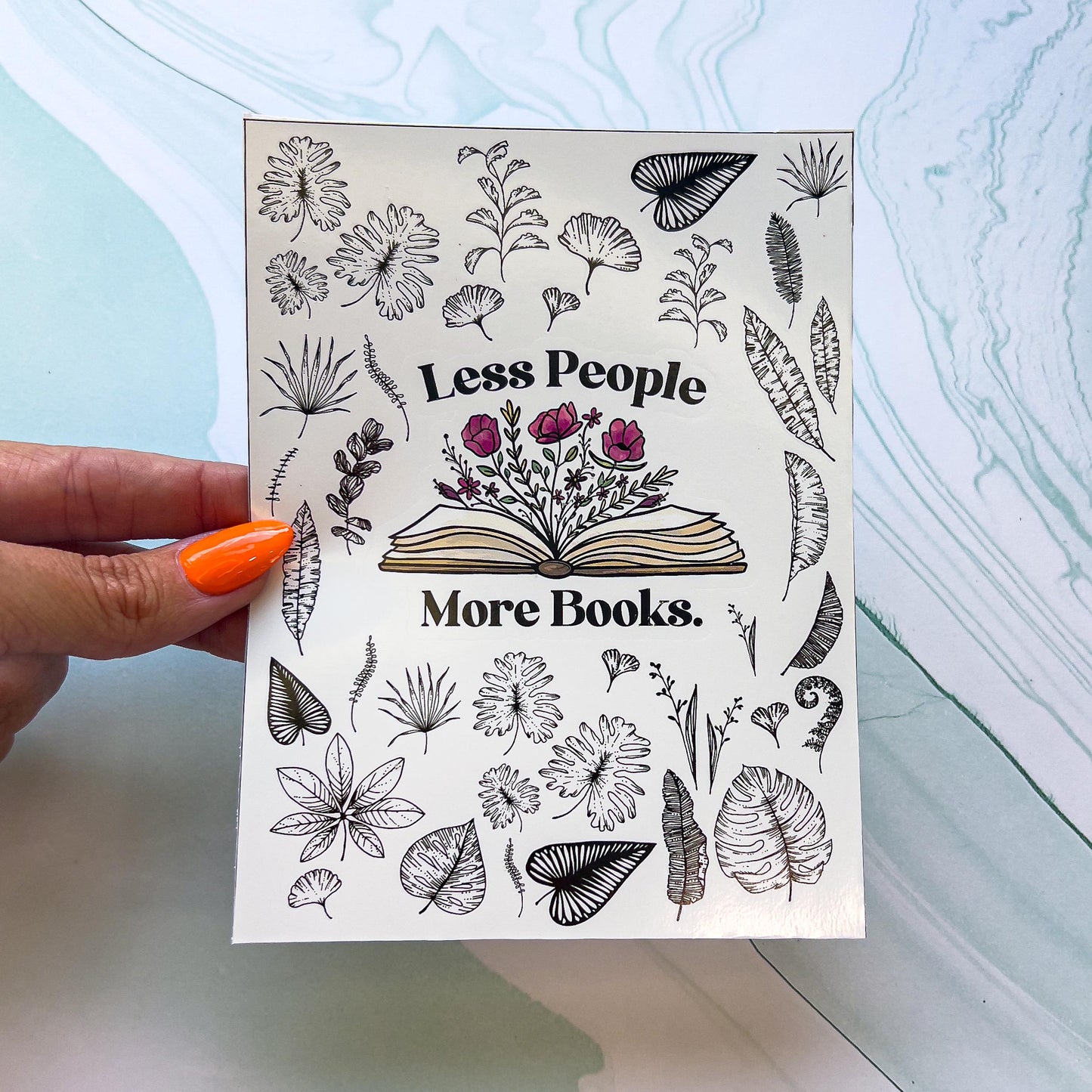 A sheet of stickers. The stickers include an open book with flowers growing from the pages and the words "Less People More Book" around the book and various black and white leaves.