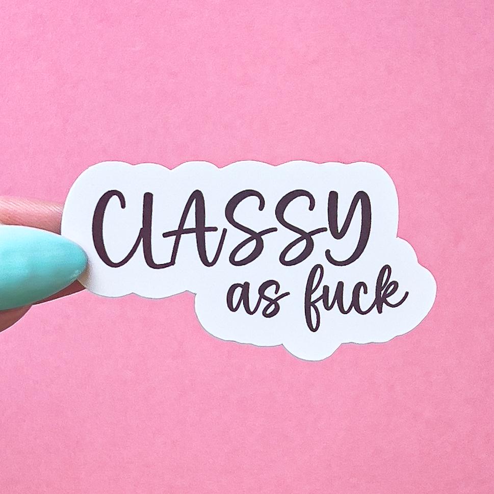 A vinyl decal sticker with black, cursive text that reads 'CLASSY as fuck'.