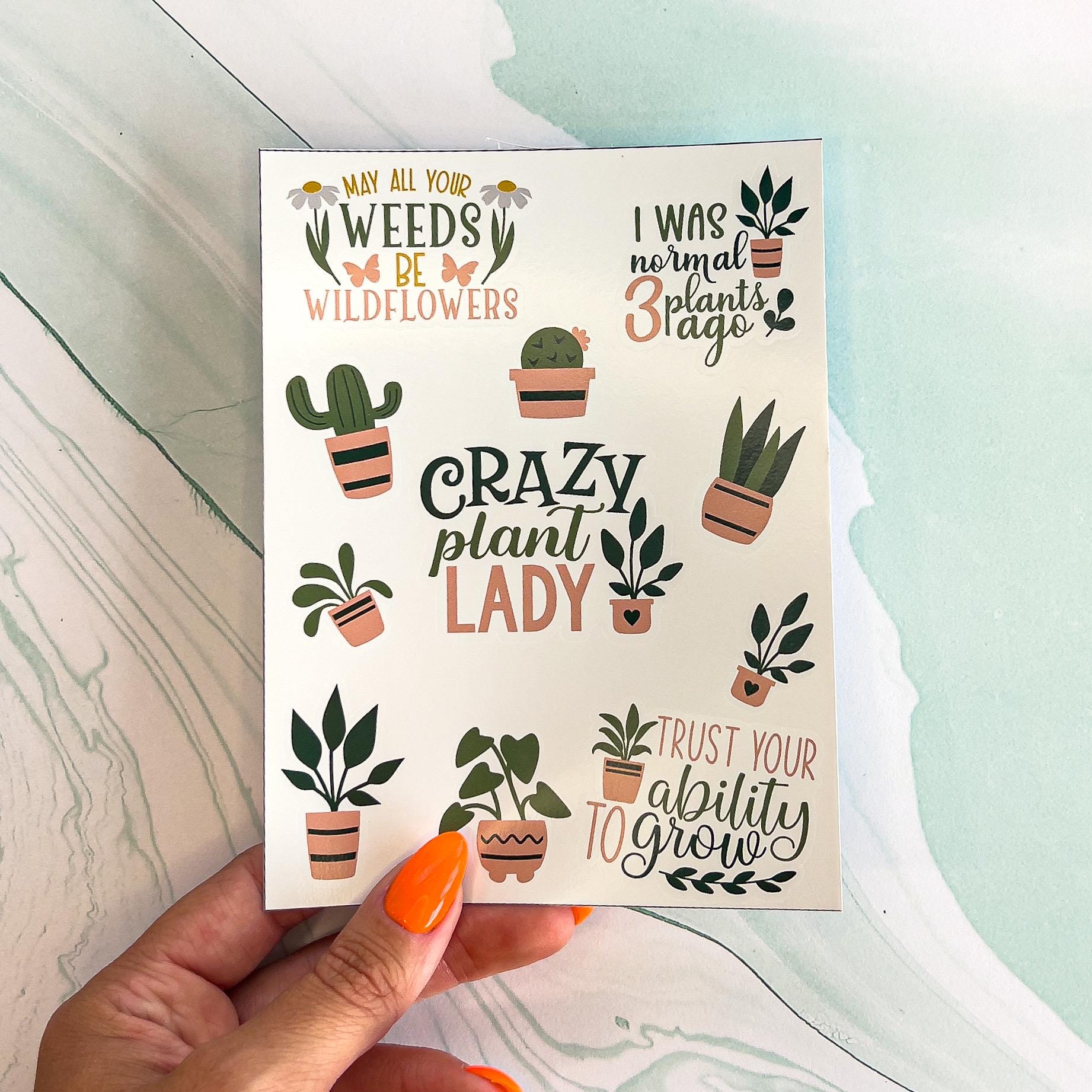 A sheet with various plant themes stickers in green and mauve colors. The stickers include a mix of house plants and plant themed sayings. The saying include: "I was normal three plants ago", "May all your weeds be wildflowers", "Crazy plant lady", and "Trust your ability to grow"  in styled text.