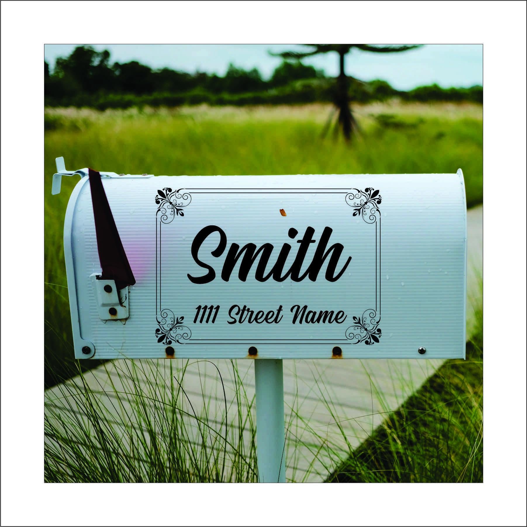 A custom vinyl decal sticker for mailbox with a vintage style, black flourish design in the corners of a rectangle and the name 'Smith' and street address printed on it, this would be replaced with your name and address.