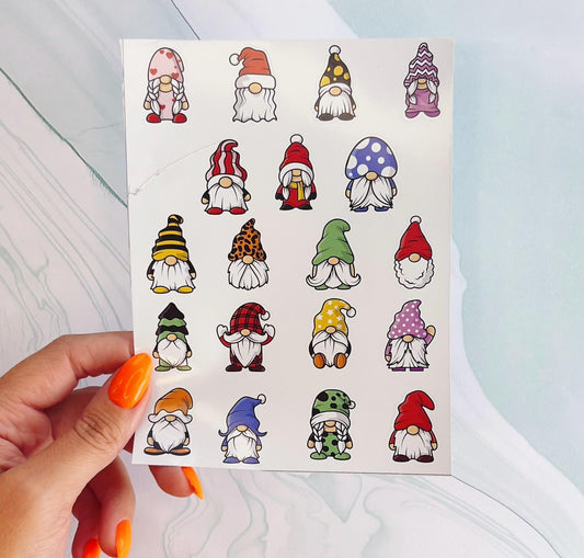 A sheet of stickers with 18 different gnomes. The gnomes are all wearing different colored hats and clothing. The gnomes are all smiling and have white beards. The gnomes are all different sizes and shapes.