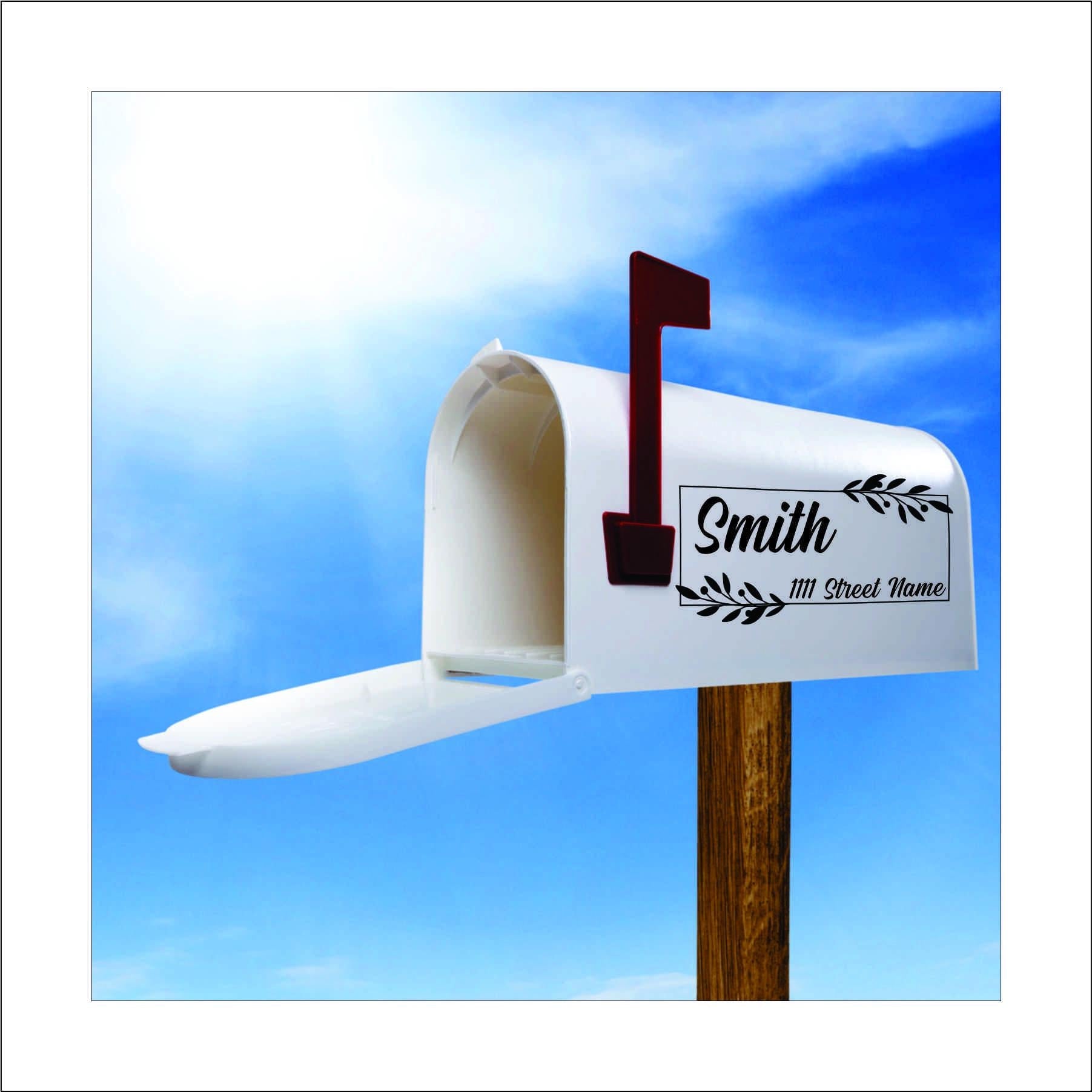 A custom vinyl decal sticker for mailbox with black vine like leaves in the corners of a rectangle design and the name 'Smith' and street address printed on it, this would be replaced with your name and address.