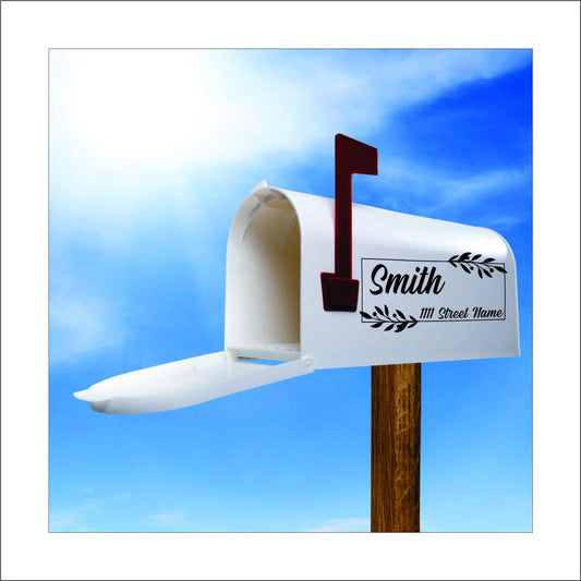 A custom vinyl decal sticker for mailbox with black vine like leaves in the corners of a rectangle design and the name 'Smith' and street address printed on it, this would be replaced with your name and address.