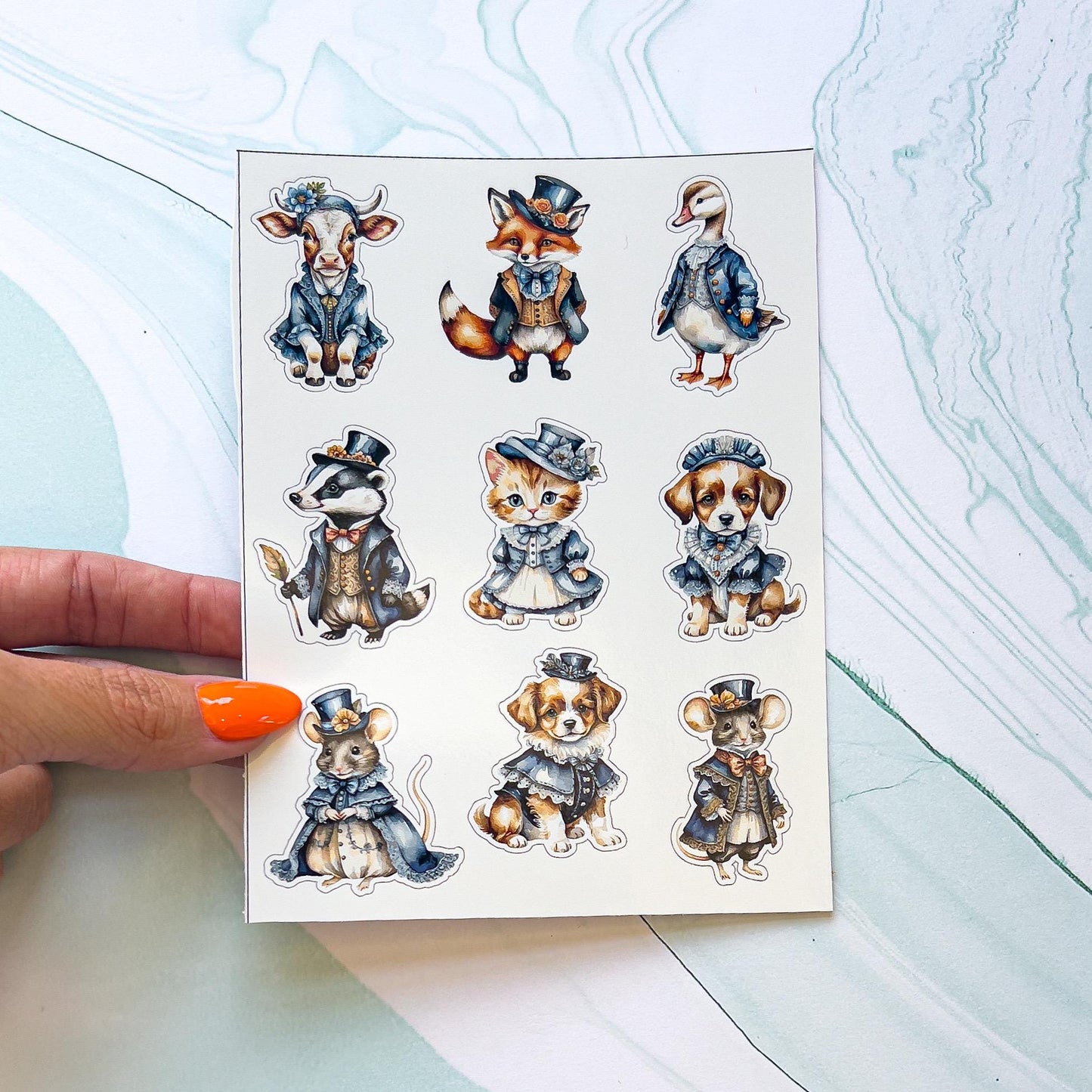 A sheet of various animal stickers wearing Victorian style clothing. The animals include a cow, badger, cat, dogs, mice, goose/duck, and fox.