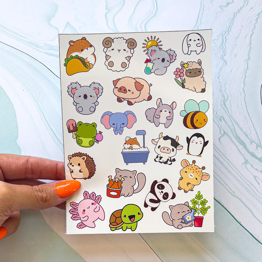 A sheet of various cartoon kawaii style animal stickers. The stickers include a hamster with a taco, an elephant, hedgehog, a frog with ice cream, a turtle, penguin, bee, a koala with drink, a hamster in a  bathtub, a cat watering a plant, a sheep with a flower, a cat with a bucket of chicken, a panda, a salamander, a squirrel, a cow, ect.