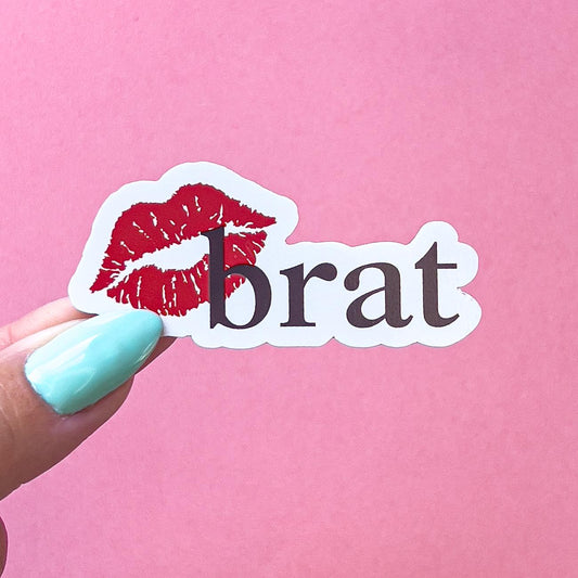 A vinyl decal sticker with a red lip print and the word 'brat' in black text.