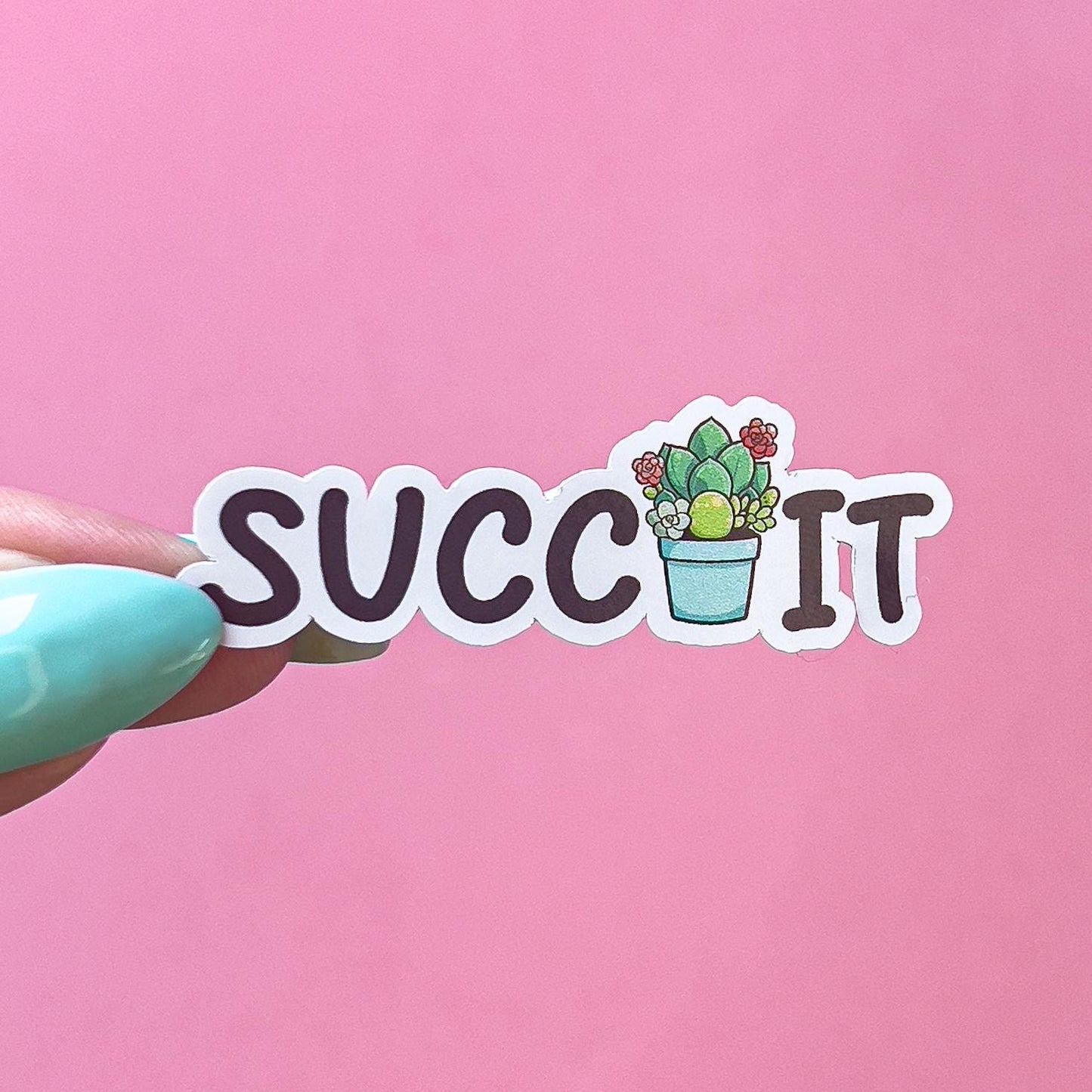A vinyl decal sticker that reads "SUCC IT" in black text. In between the two words is a green, red, and blue green succulent plant in a light blue pot.