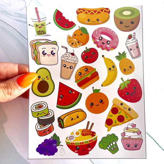 A sheet of colorful stickers featuring various food items with cartoon faces. The stickers include a hot dog, donut, watermelon, avocado, sushi, pizza, cupcake, pineapple, banana, strawberry, orange, kiwi, broccoli, and a bowl of ramen noodles.