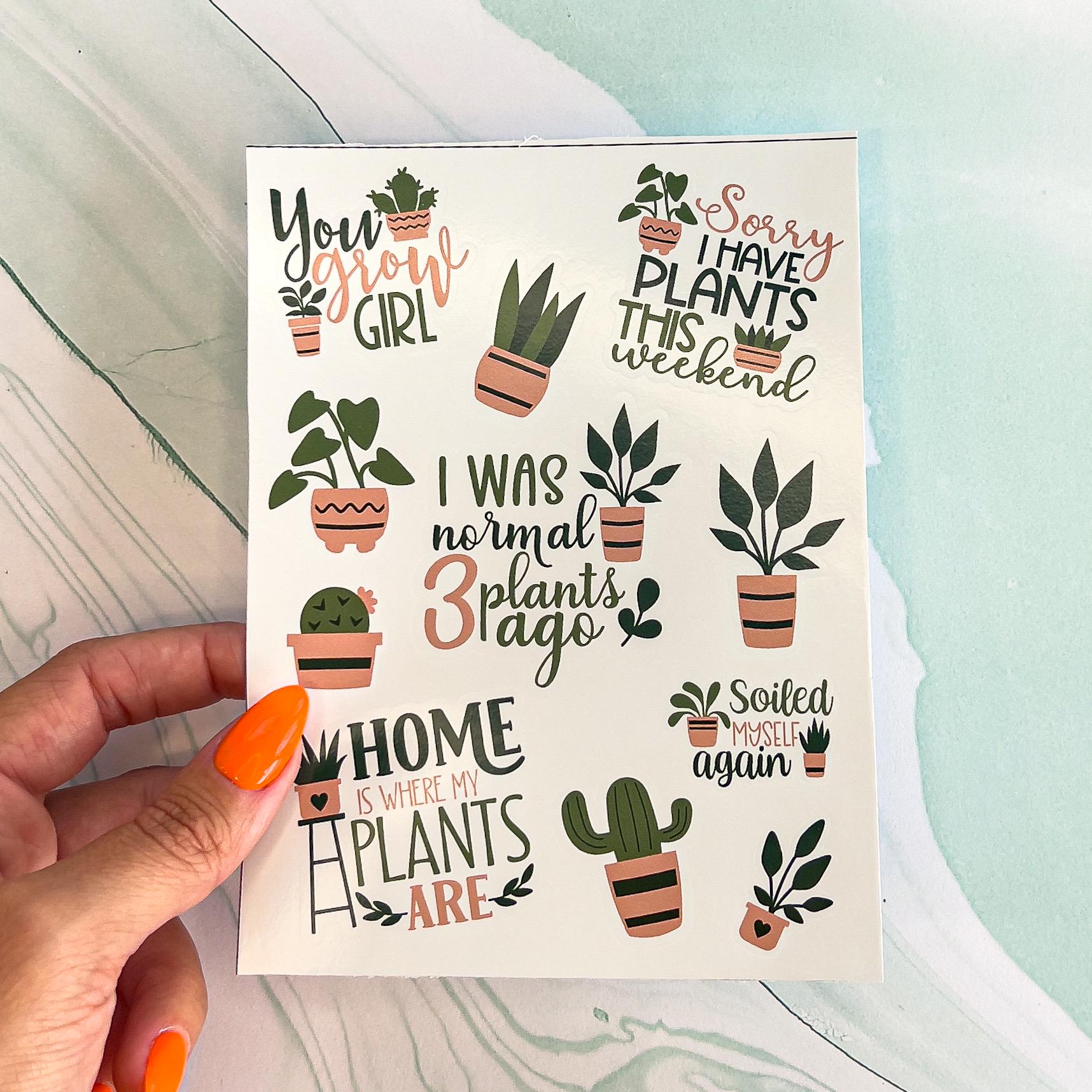 A sheet with various plant themes stickers in green and mauve colors. The stickers include a mix of house plants and plant themed sayings. The saying include: "You grow girl", "Home are where the plants are", "I was normal three plants ago", "Soiled myself again", and "Sorry I have plants this weekend", in styled text.